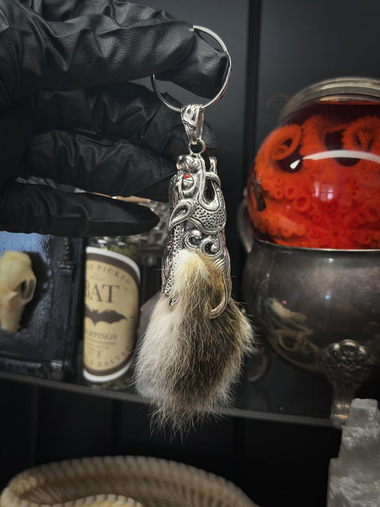 Lepidora Entomology rabbit tail keychain featuring a soft, plush rabbit tail with a metal keyring attachment.